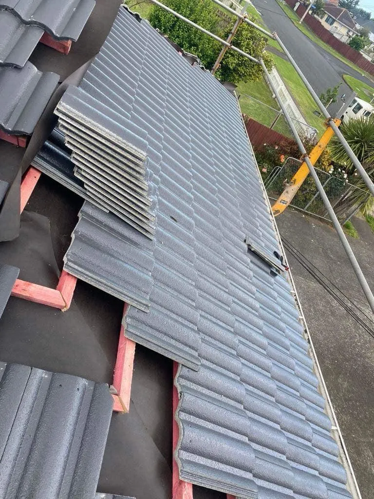 Removing old roofing and installing new concrete tiles on a residential roof in progress