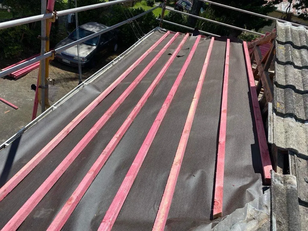 Temporary edge protection system installed on a tiled roof for roofing safety compliance