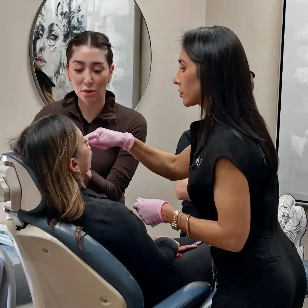 Marisa Escobar teaching facial anatomy and injection techniques to students in a training session.