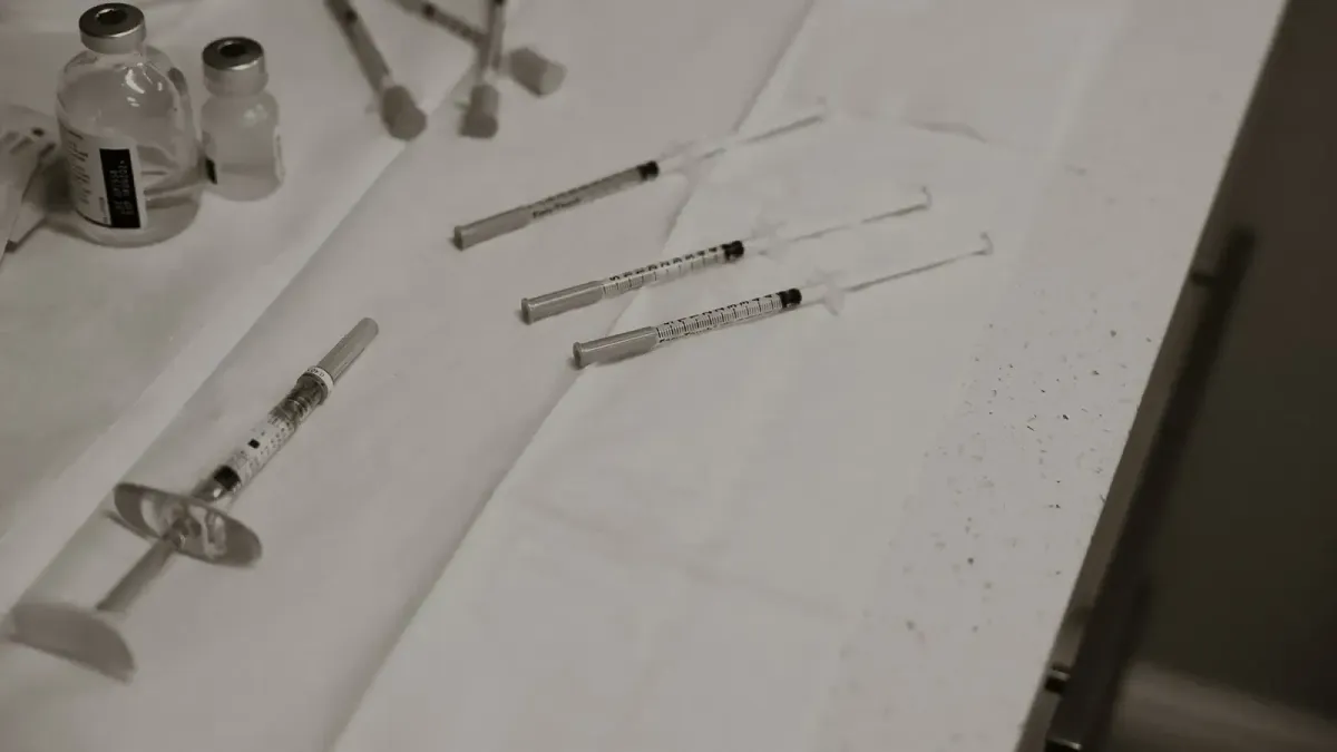 Syringes and vials arranged on a sterile white surface for injectable treatments in a clinical setting.