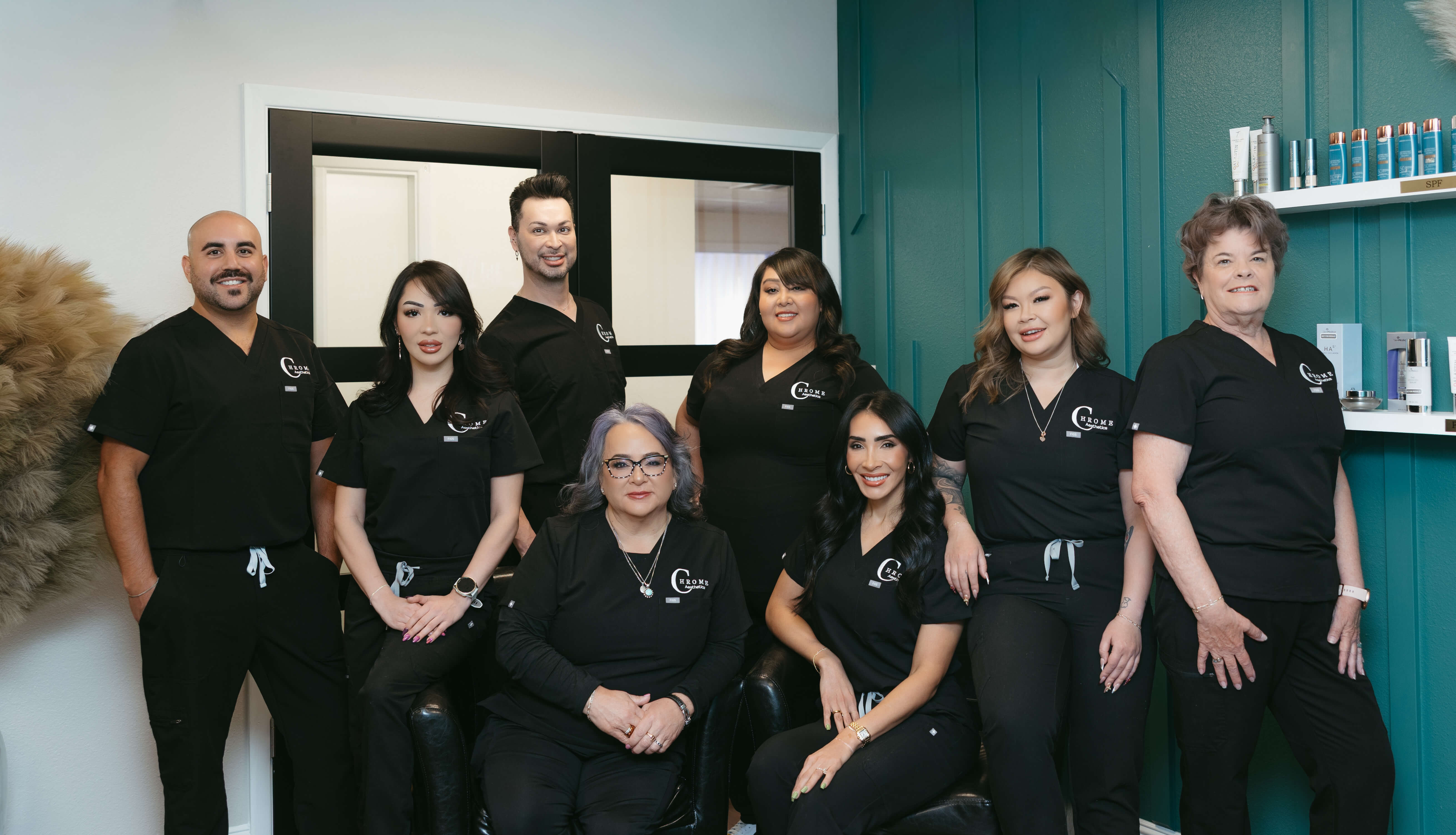 Chrome Aesthetics team group photo with smiling staff members standing together and looking happy in the clinic.