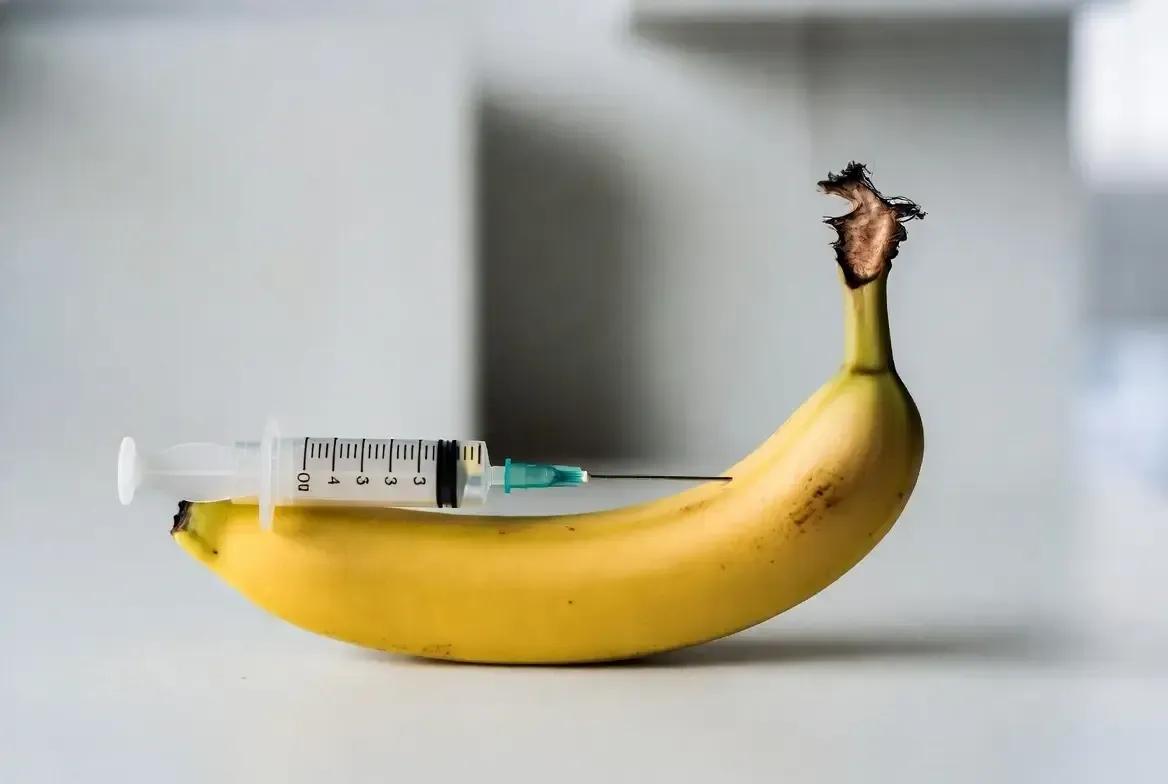 Image of a banana with a syringe inserted into it, used as a visual metaphor for the P-Shot (Priapus Shot) treatment.