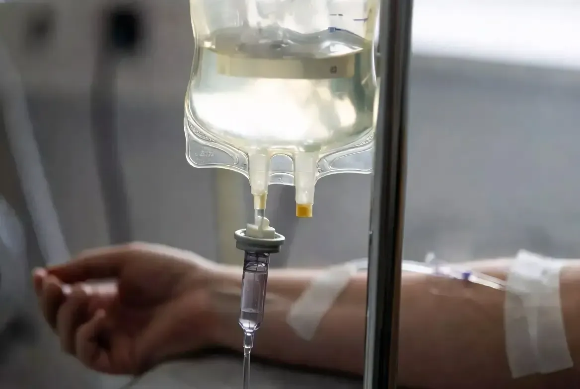 IV nutrient therapy bag and infusion line connected to a patient’s arm during a wellness treatment in a clinical setting.