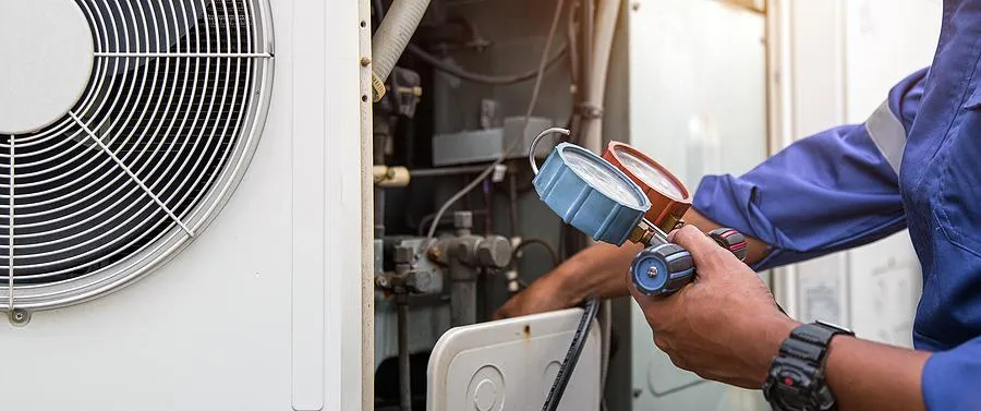 HVAC technician using pressure gauges to diagnose system performance
