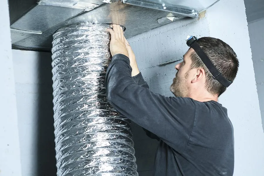 HVAC technician installing new ductwork in residential system