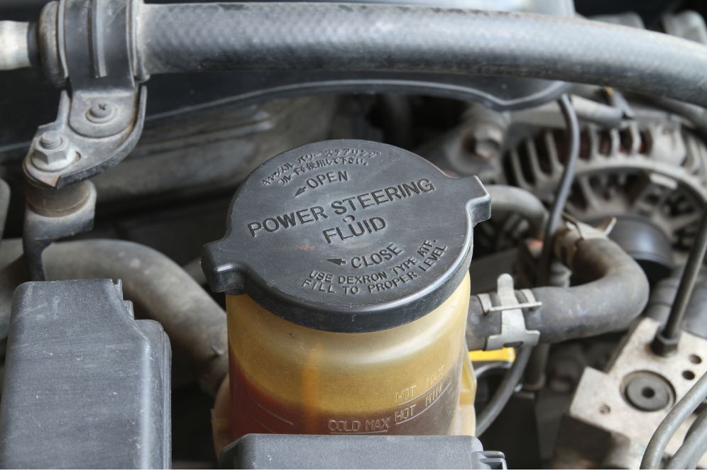 Power steering fluid botte installed in a car engine