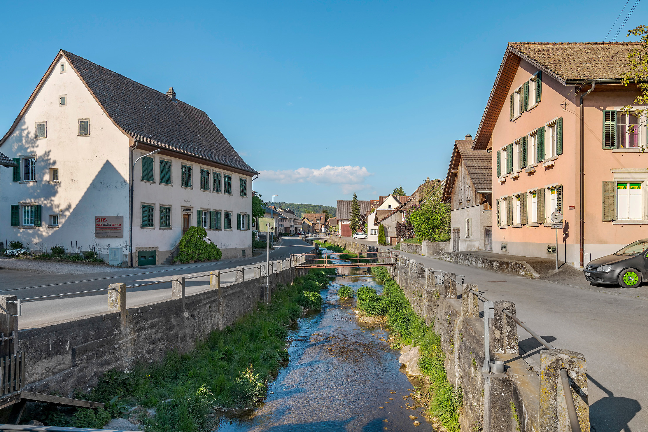 Ein quadratisches Bild eines alten Pergamentmanuskripts mit handgeschriebener deutscher Schrift, das auf einem Holztisch neben einer Feder und einem Tintenfass liegt. Sanftes natürliches Licht hebt die Textur des Papiers hervor und vermittelt ein Gefühl historischer Authentizität und Ehrfurcht vor dem Dokument.