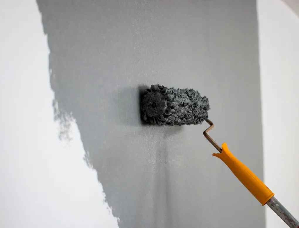 Professional handyman repairing kitchen cabinet in modern white kitchen providing expert home repair and maintenance services for homeowners in North Carolina