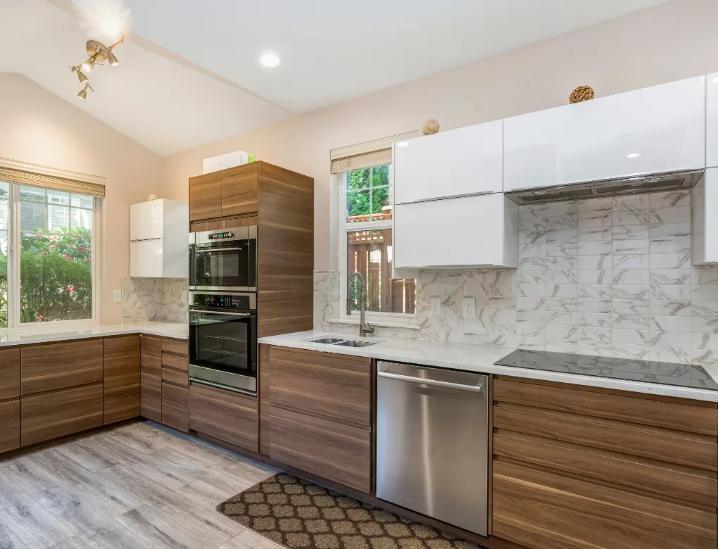 Professional handyman repairing kitchen cabinet in modern white kitchen providing expert home repair and maintenance services for homeowners in North Carolina