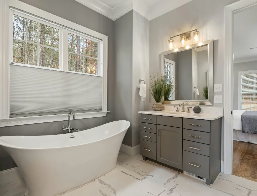 Professional handyman repairing kitchen cabinet in modern white kitchen providing expert home repair and maintenance services for homeowners in North Carolina