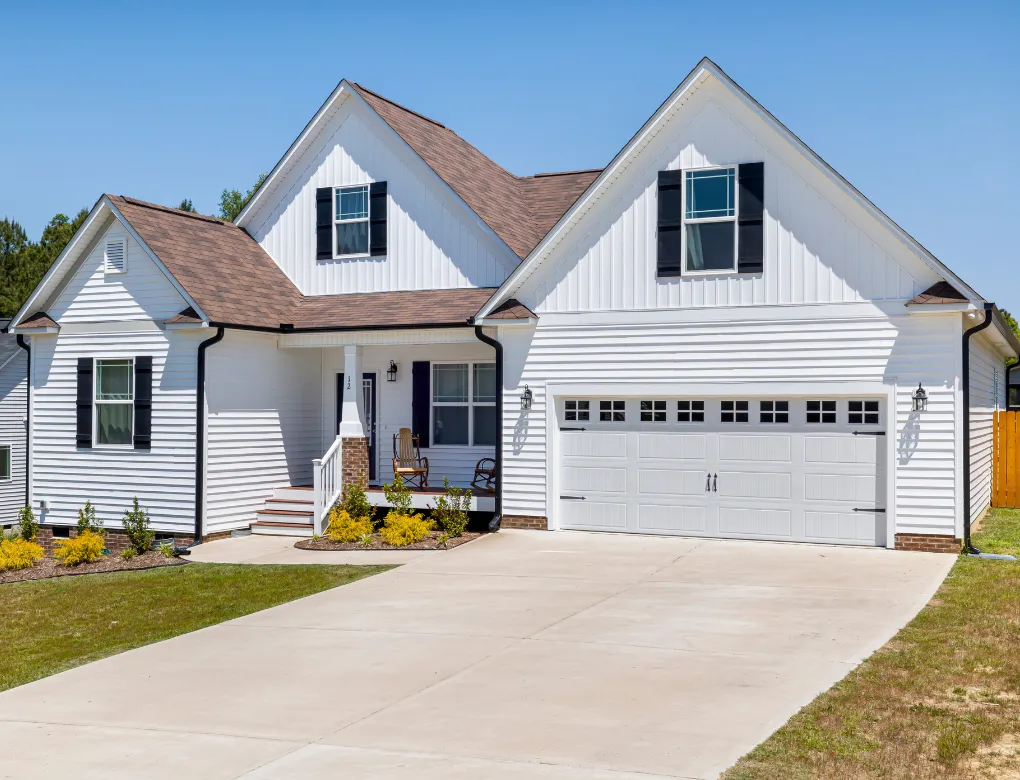 Professional handyman repairing kitchen cabinet in modern white kitchen providing expert home repair and maintenance services for homeowners in North Carolina