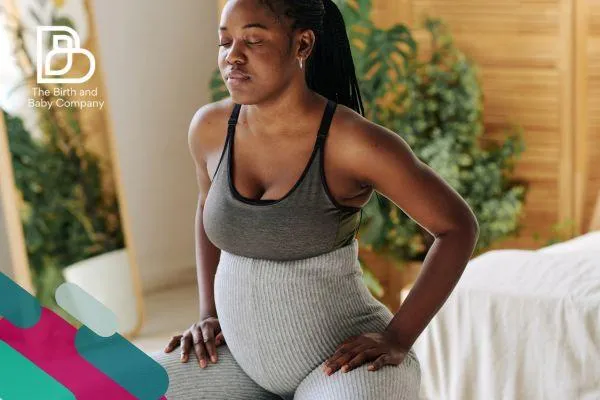 A pregnant woman in workout gear appearing to squat as part of a prenatal exercise routine.