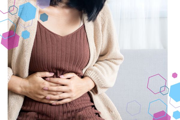 Person sitting and holding their lower abdomen, illustrating mild cramping that can occur in early pregnancy. Early pregnancy cramping at 4–8 weeks, often described as period-like pain.