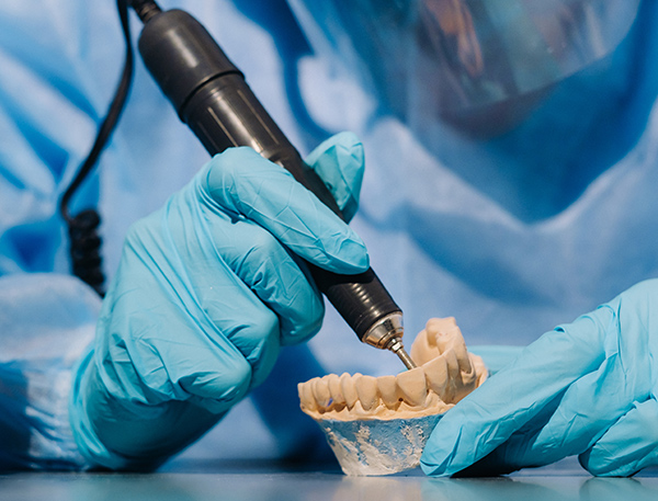 Certified dental technician hand-finishing a custom night guard model in our Irish laboratory.
