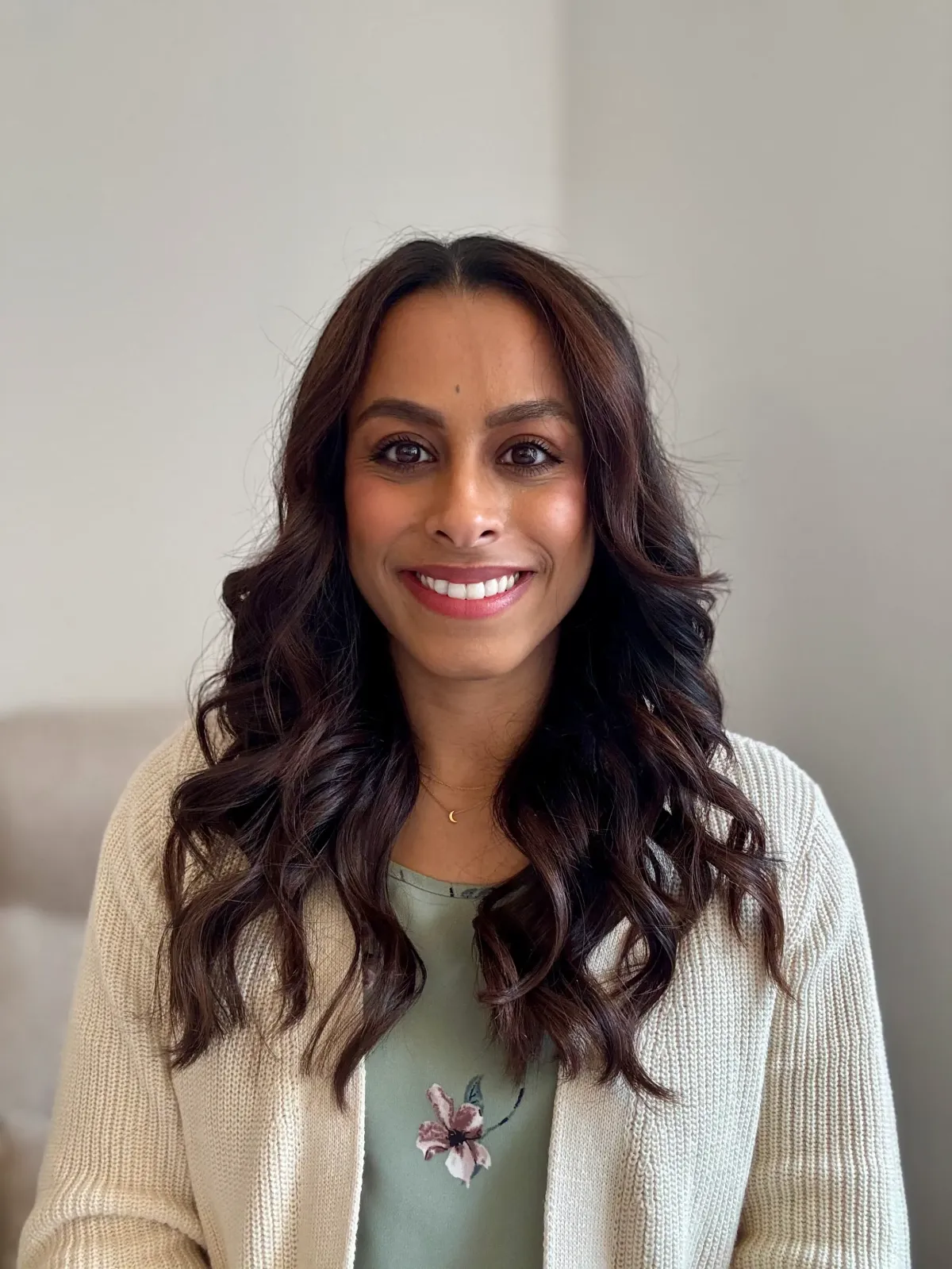 Darshana Patel, therapist and founder of Clear Moon Therapy, smiling warmly while wearing a beige cardigan, representing mental health and compassionate care.