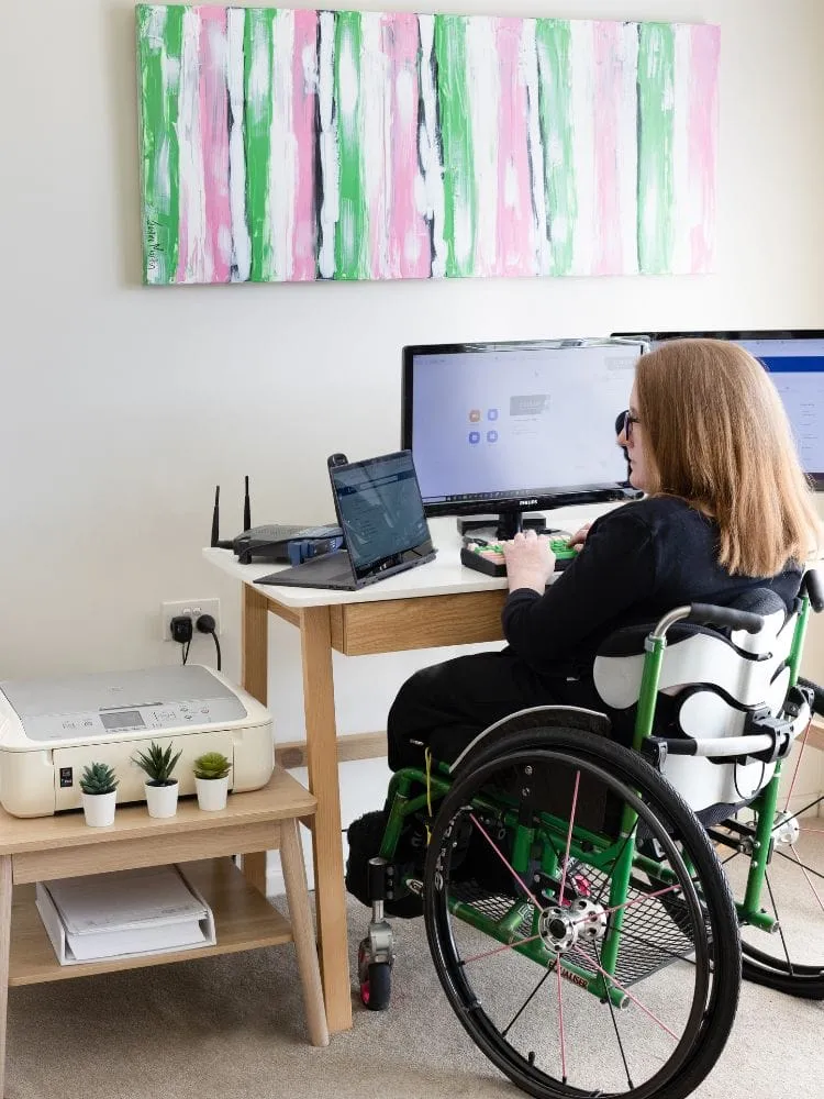 Ainslee Hooper working at her desk in her wheelchair