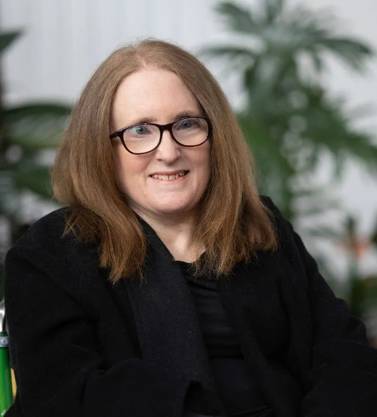 Ainslee Hooper smiling, wearing glasses and a black top