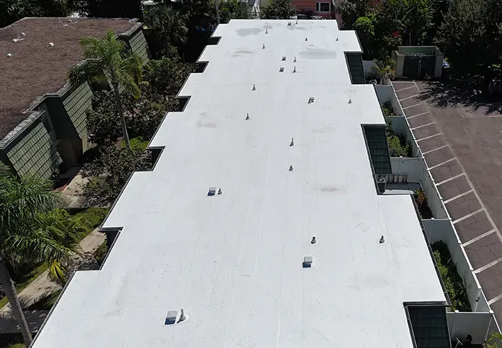 Aerial view of flat white roof replacement on commercial building in Florida
