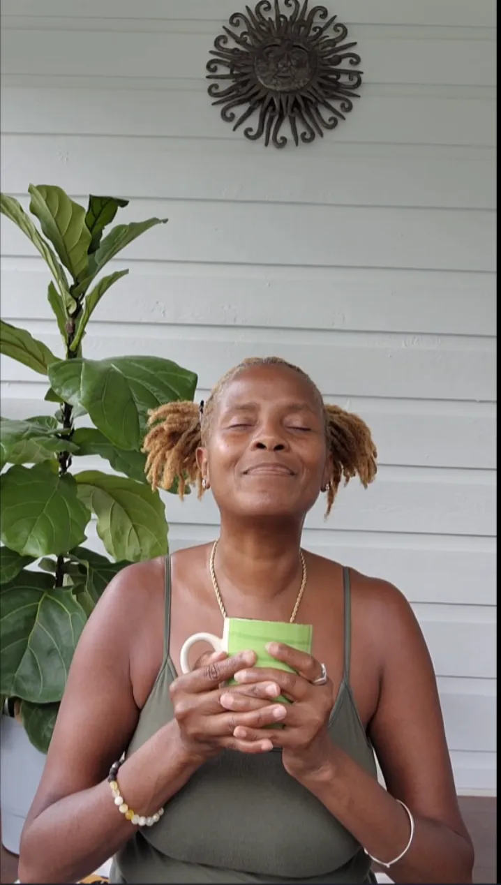 Serene African American woman in her 50s laughing joyfully, bathed in golden hour light
