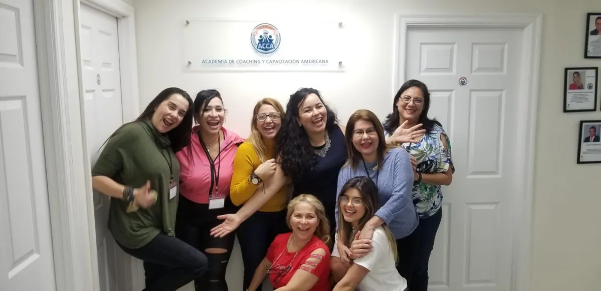 Mentor guiando a un grupo multicultural de estudiantes en una sesión interactiva de coaching, con pizarras llenas de ideas y ambiente inspirador.
