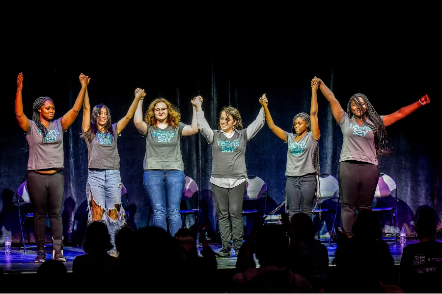 Teens on stage holding hands