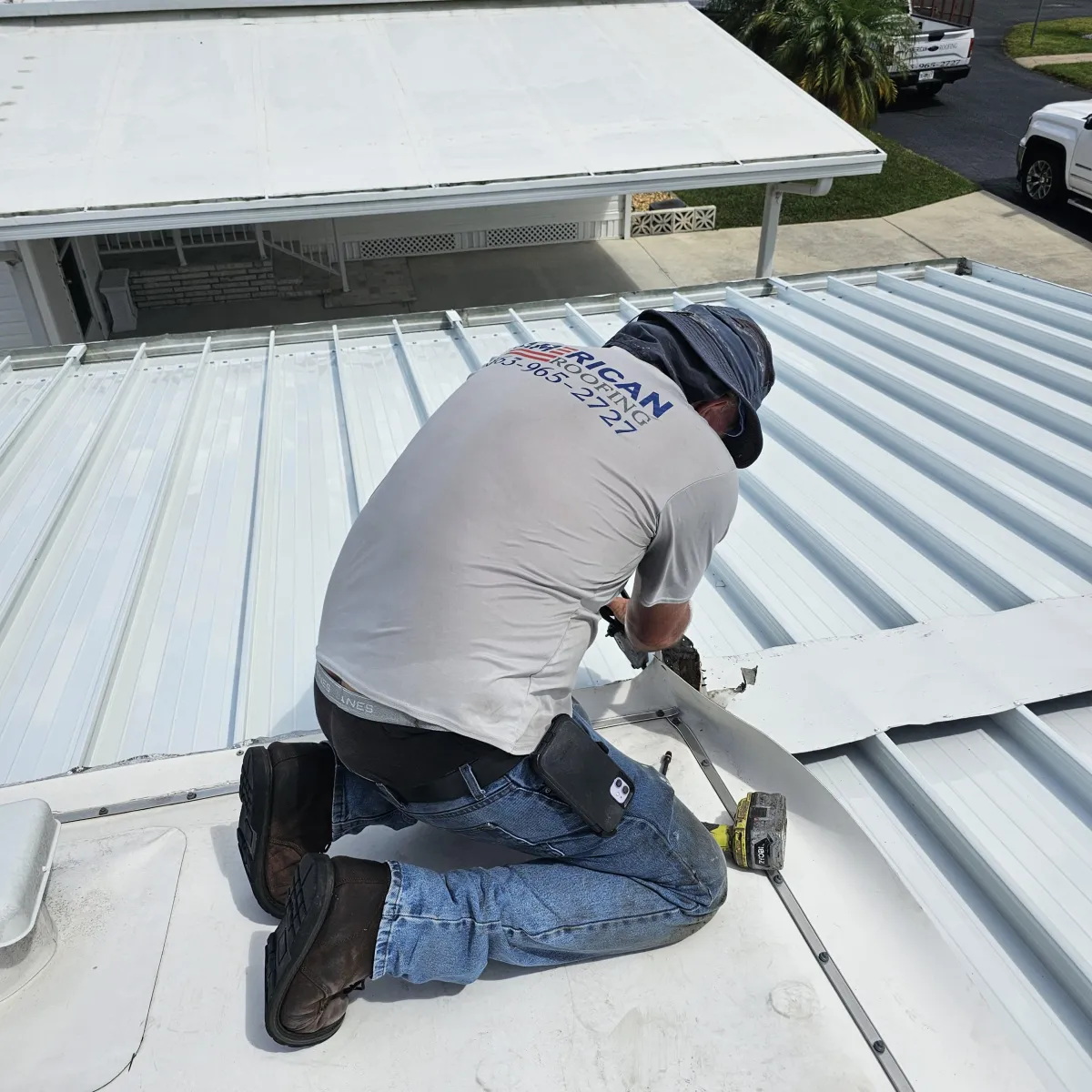 Roof replacement crew installing new plywood decking on residential roof frame.