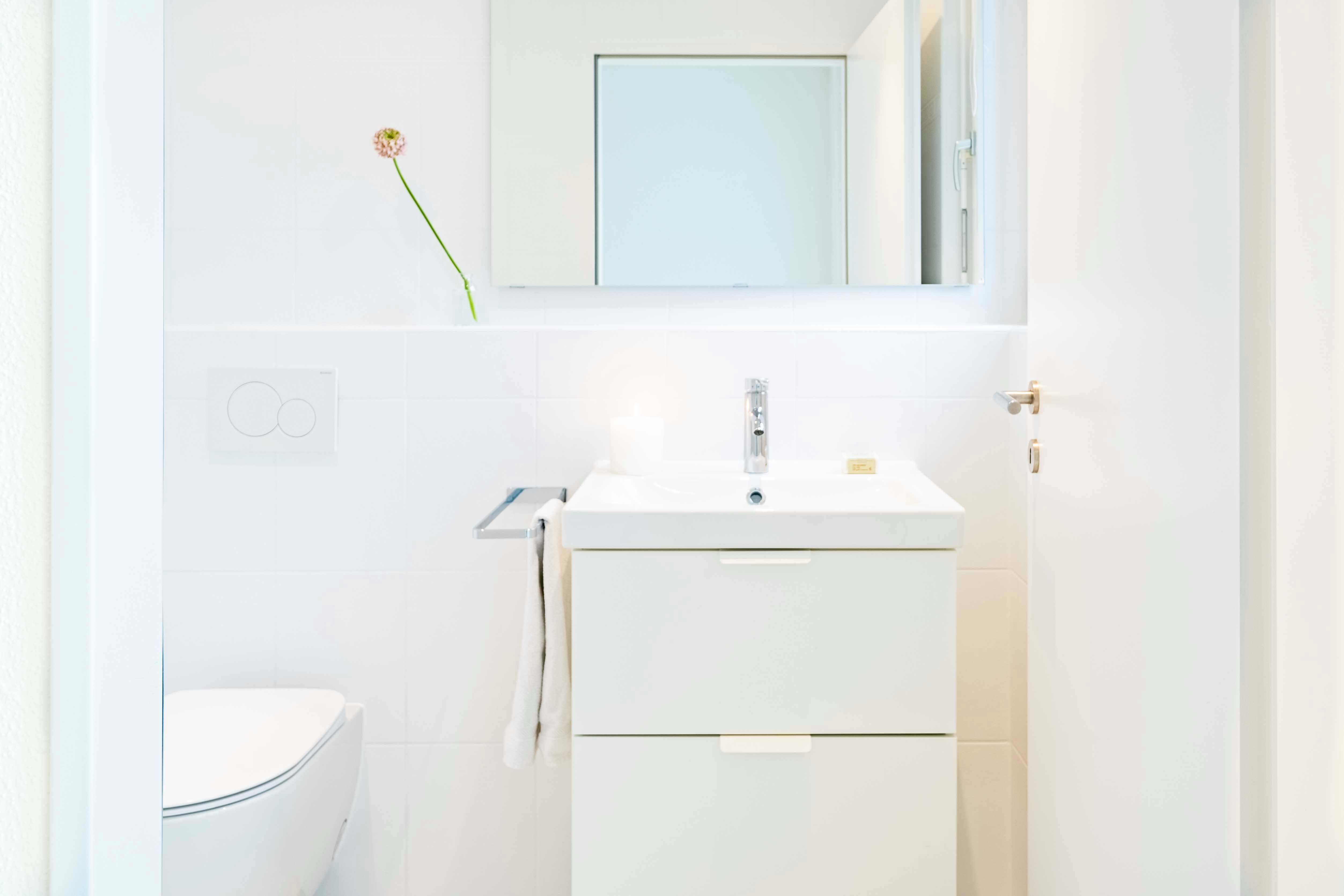 white toilet facing sink and mirror