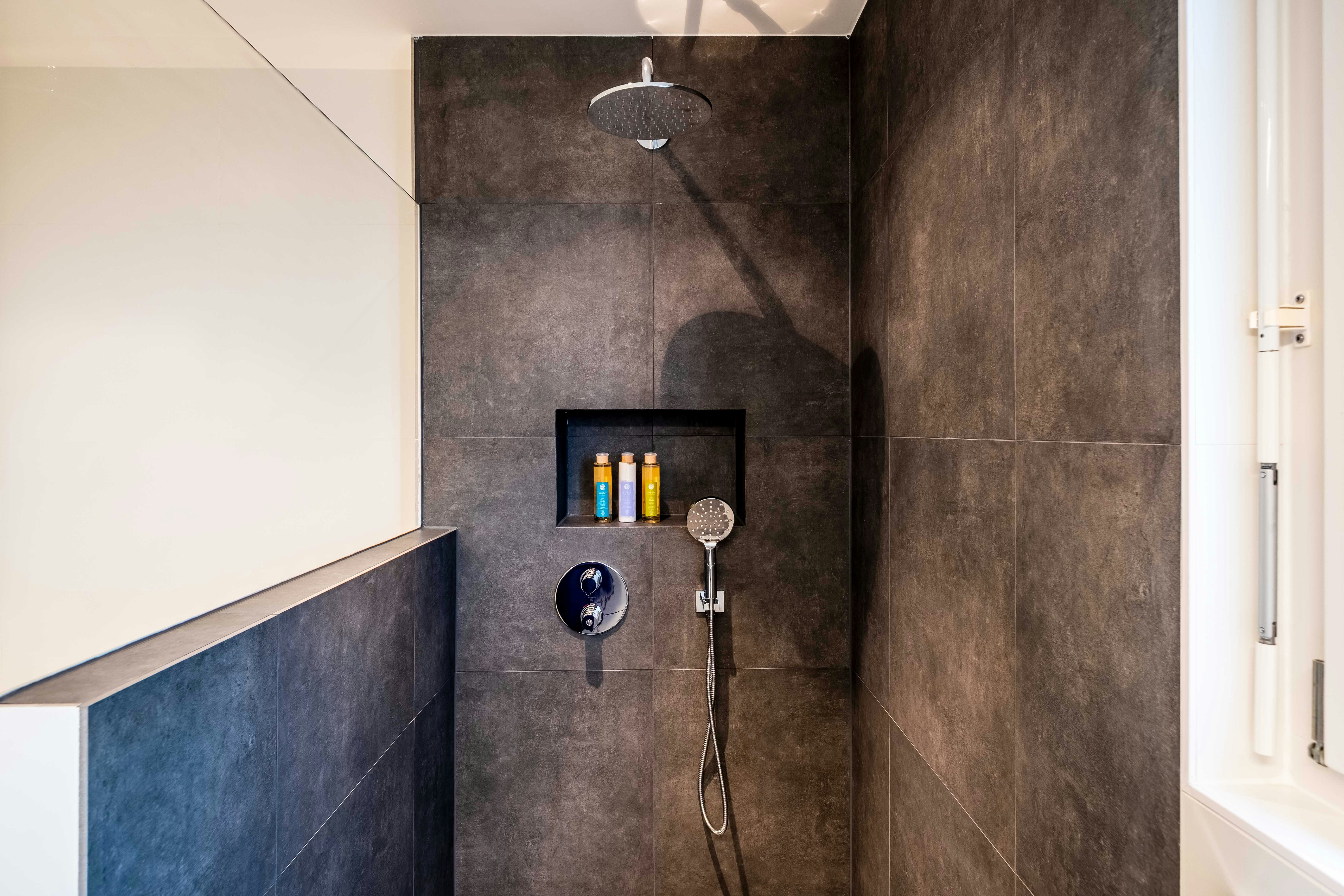 open shower with black tiles