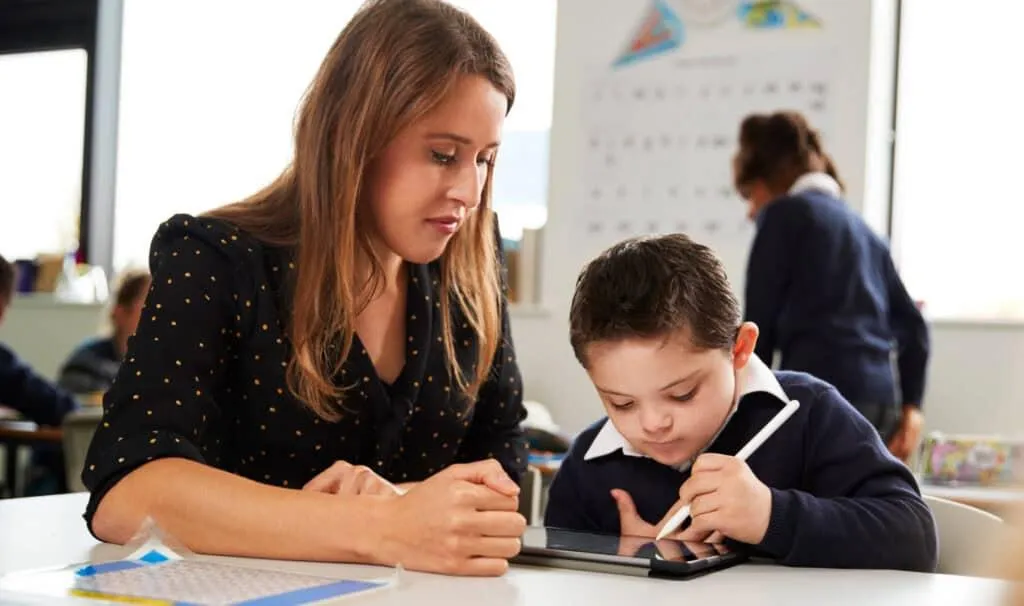 a young girl is holding a cross made of paper