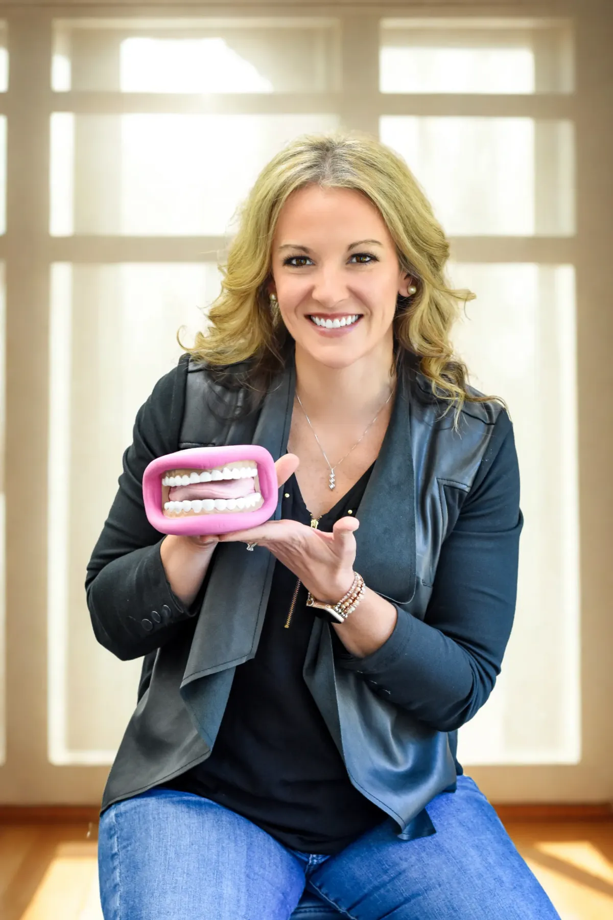 Adult patient performing guided myofunctional exercise in clinic, smiling in soft natural light.