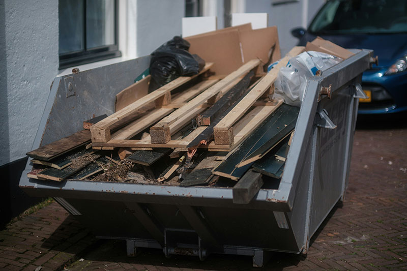 a large truck with a load of trash in a warehouse