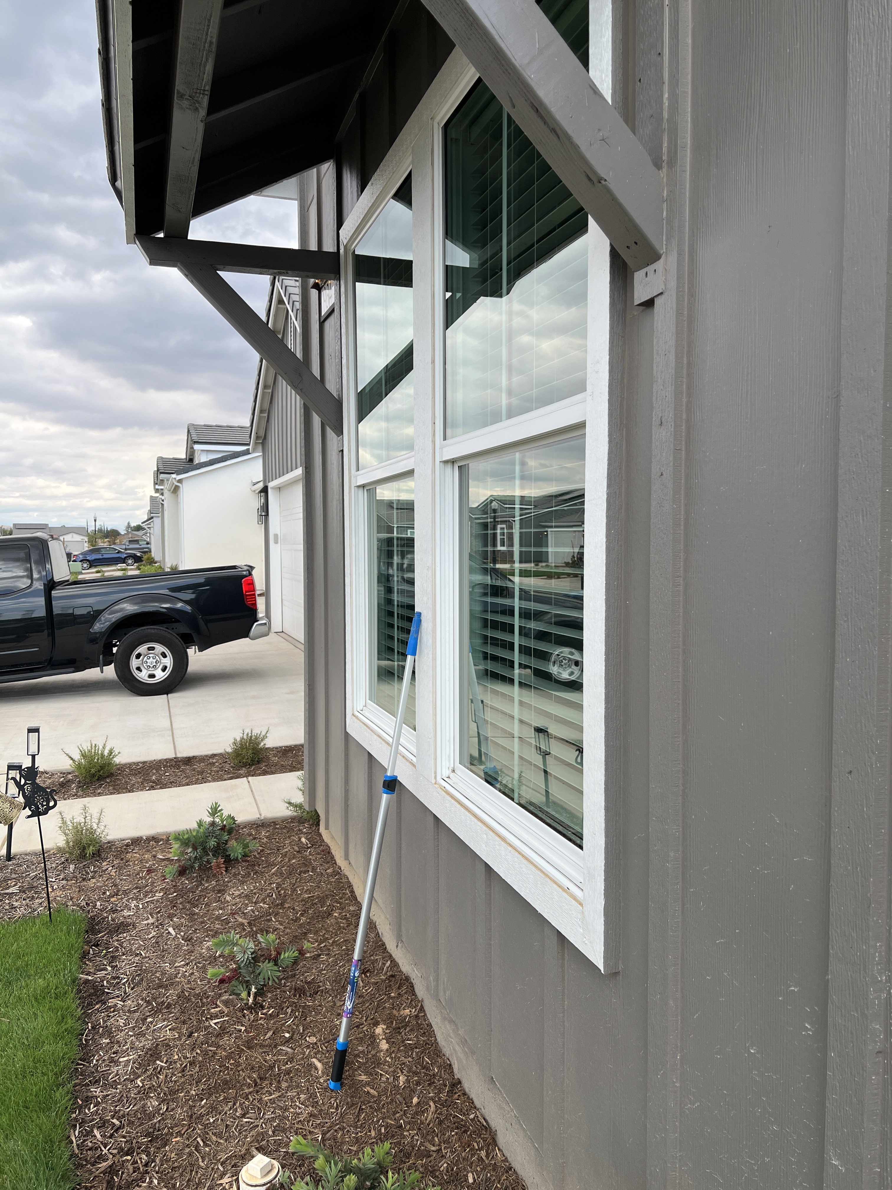 Technician cleaning residential exterior windows in Fresno, CA