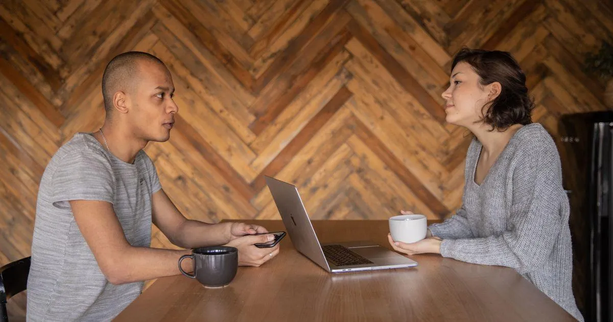Two sober living home operators reviewing an opening checklist inside a furnished house