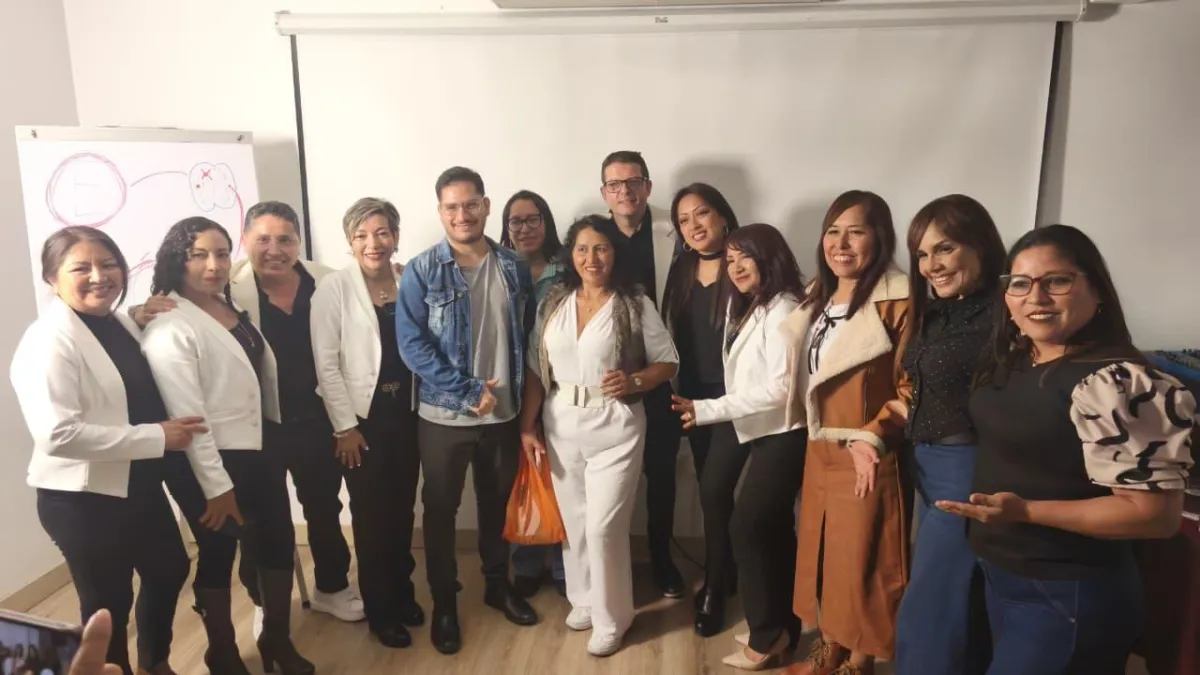 Grupo diverso de asesores inmobiliarios sonrientes en círculo, compartiendo ideas en un espacio moderno y luminoso, con luz natural y ambiente relajado, estilo realista, composición horizontal, fondo blanco minimalista