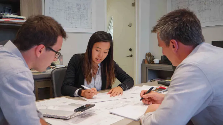 Architectural Design Coordination Perth showing architects reviewing building plans at a table in Claremont.