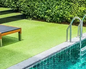 A pristine rectangular swimming pool next to a perfectly manicured lawn