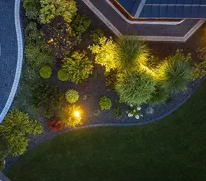 Landscape lighting highlighting shrubs and a patio edge at night