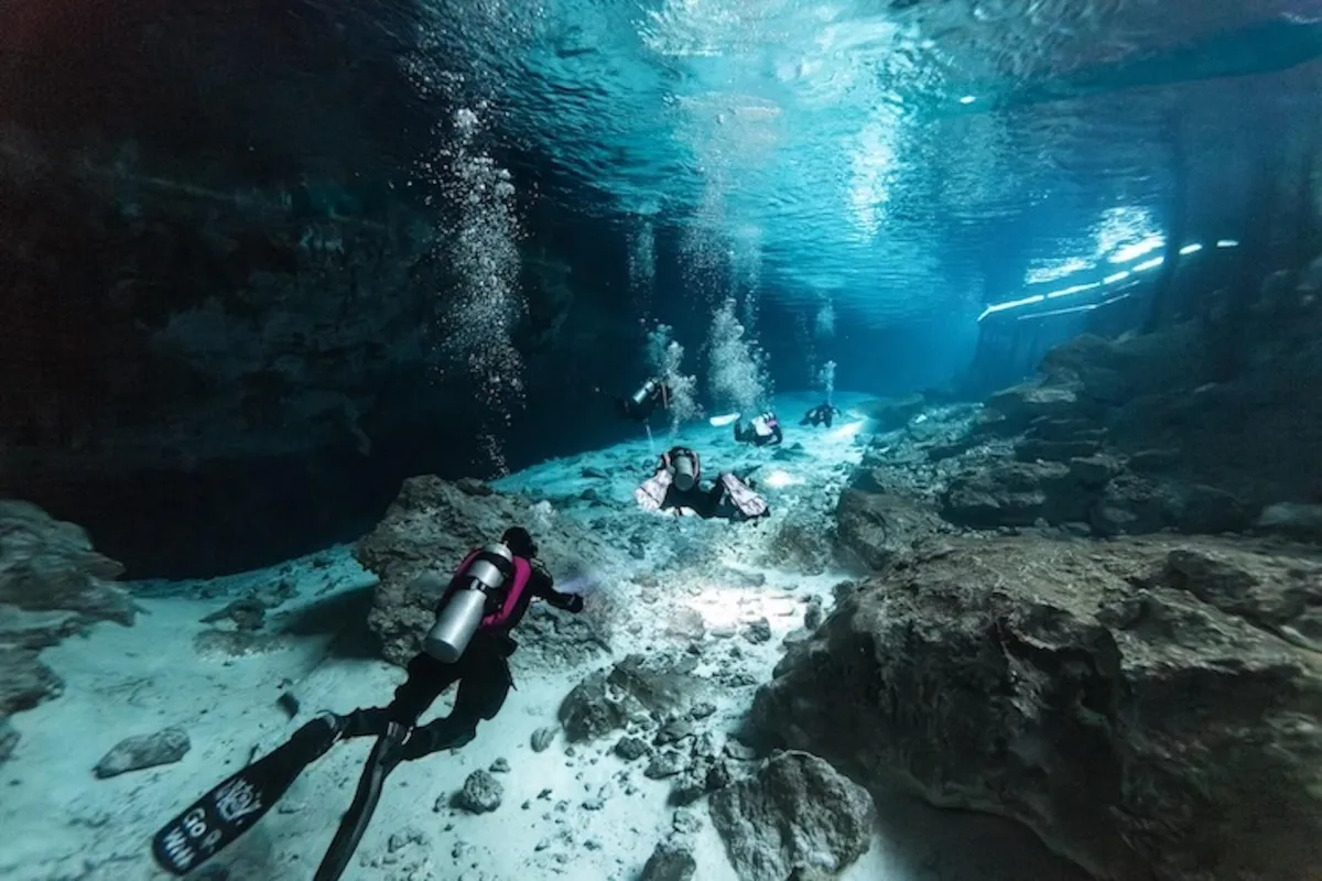 Divers swimming along the Barbie Line at Dos Ojos cenote