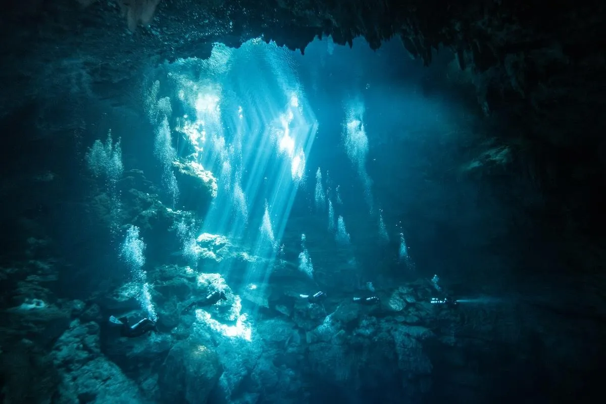 Scuba diver exploring stalactites inside Dos Ojos cenote cavern
