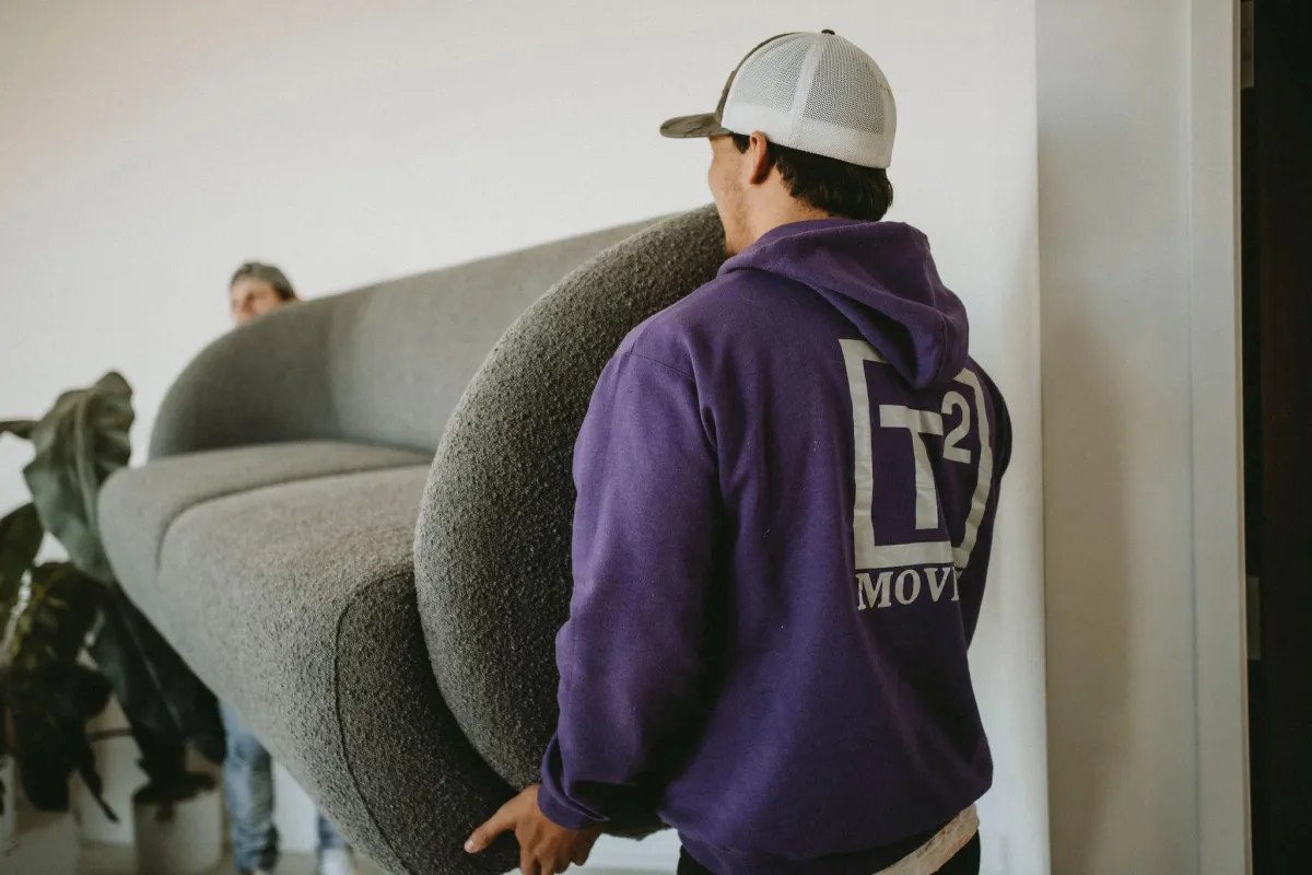 two movers carrying a couch