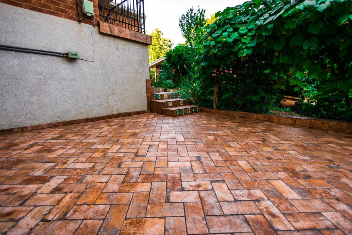Alpine project: patterned outdoor tile patio beside a brick home