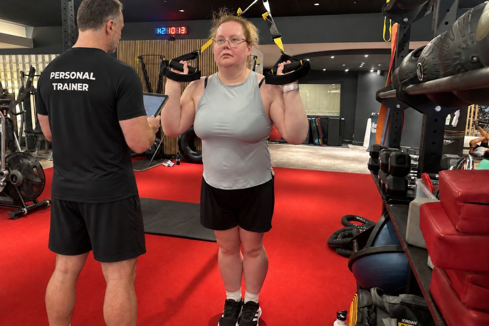 Personal trainer Rob Ede coaching a client during a strength training session at Lightwater Leisure Centre in Surrey.