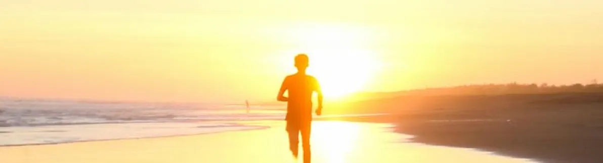 Person running along a beach at sunrise, symbolizing freedom, clarity, and momentum in life and business.