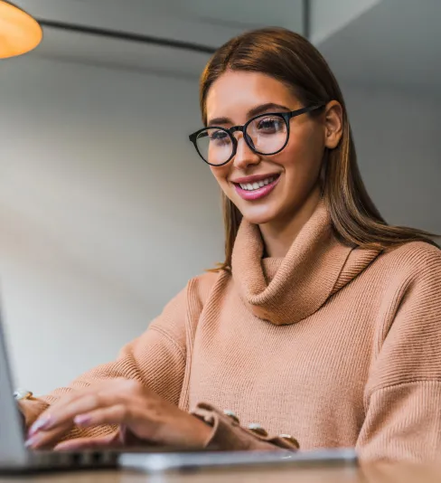 Professional woman holding a laptop, smiling confidently, representing friendly tech support or user satisfaction.
