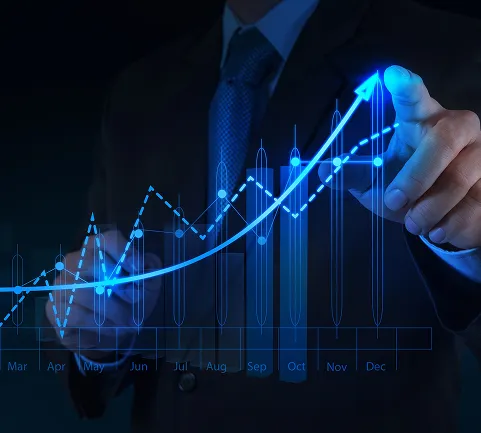 Businessman in a suit pointing to a glowing, upward-trending financial graph, representing growth and success metrics.