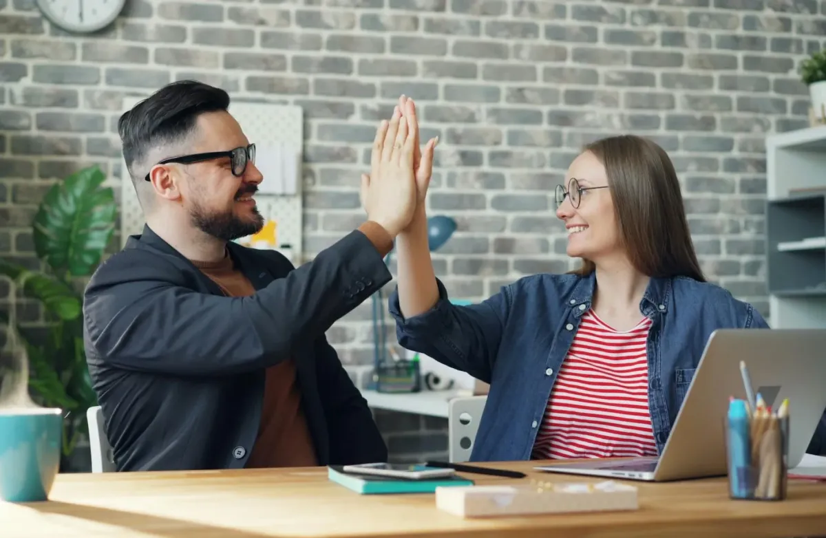 Team collaboration meeting celebrating success with Oshore business support