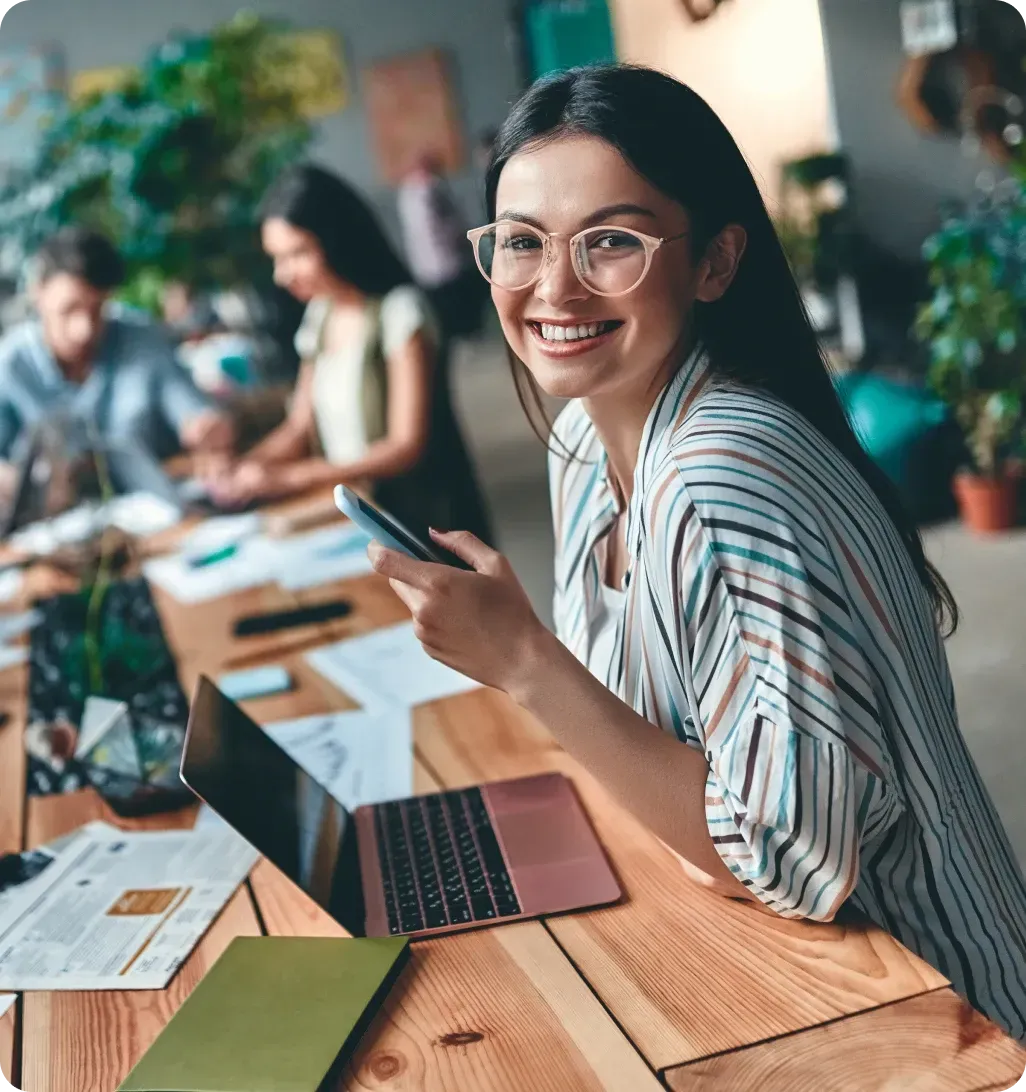 Female designer working on laptop in a creative team environment