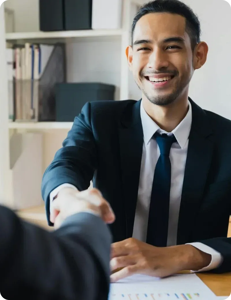 Business professional shaking hands during meeting to confirm partnership or hiring agreement