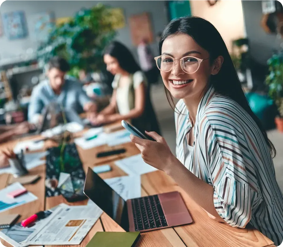 Female designer working on laptop in a creative team environment
