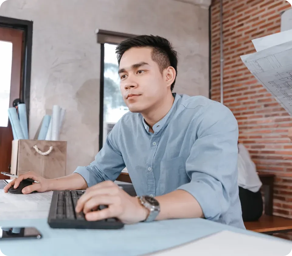 Operations professional working at desk using computer in office environment
